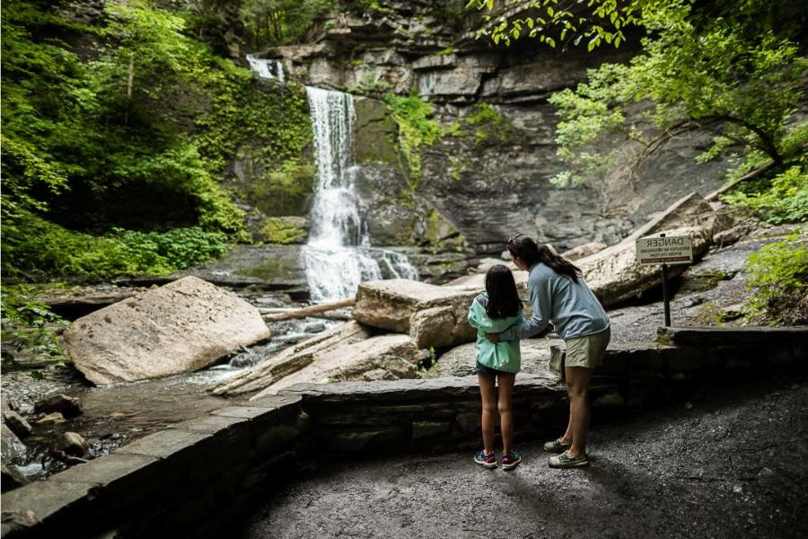 一位母亲和年幼的女儿在菲尔莫尔格伦州立公园观看瀑布